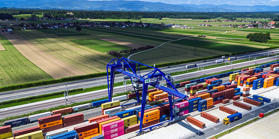 Graz container terminal with cranes handling TAILWIND containers, modern infrastructure, tracks in the foreground, 24/7 operation