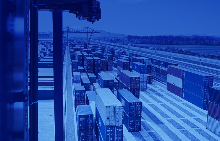 Modern container terminal with automated gantry crane, multi-track container storage rails and handling infrastructure.
