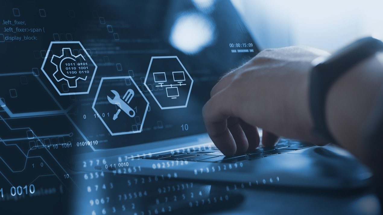 Hand typing on a laptop, overlaid with digital icons for a gear, tools, and network, representing IT Service Management (ITSM).