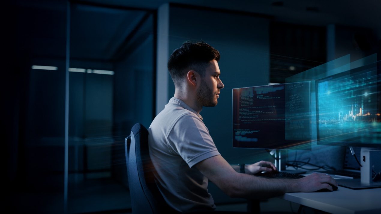 Softwareentwickler arbeitet an zwei Monitoren mit Code-Anzeige.
