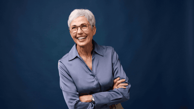 Frau mit Brille und Bluse lacht