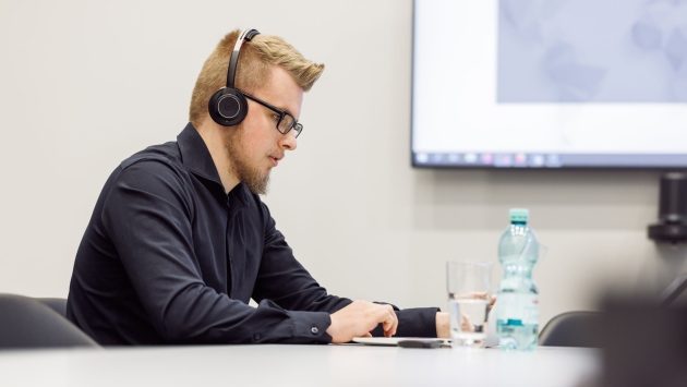 Ein Mitarbeiter sitzt im Konferenzraum an seinem Laptop.