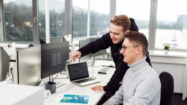 Zwei Mitarbeiter von StackIT befinden sich an einem Arbeitsplatz und schauen auf den Bildschirm.