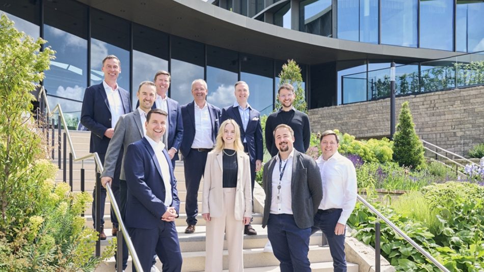 Schwarz Digits and Zscaler team standing on outdoor stairs in front of a modern office building