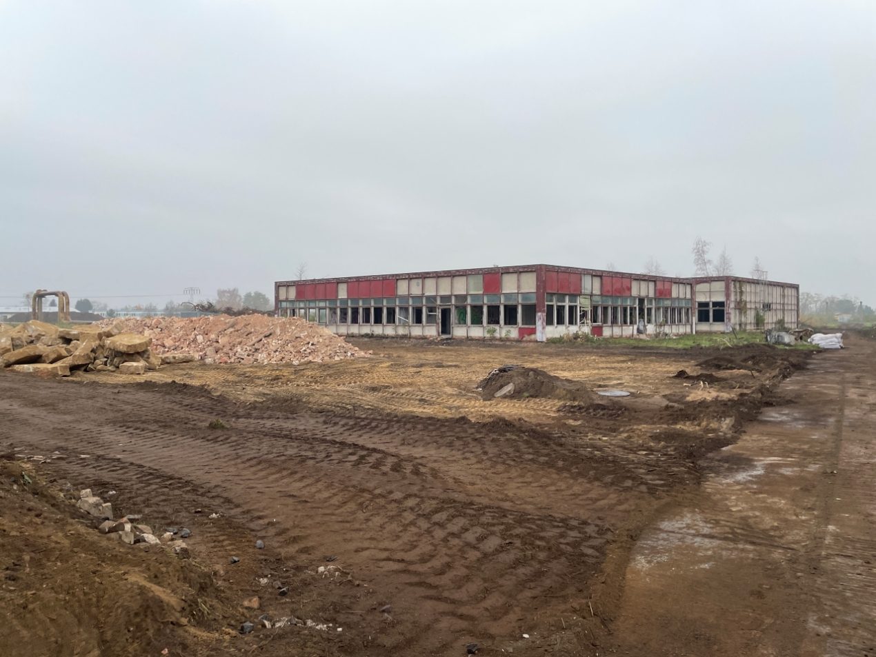 Blick auf das Baugrundstück des Schwarz Digits Rechenzentrums Lübbenau vor Baubeginn mit abgerissenem Altgebäude und Schuttbergen.
