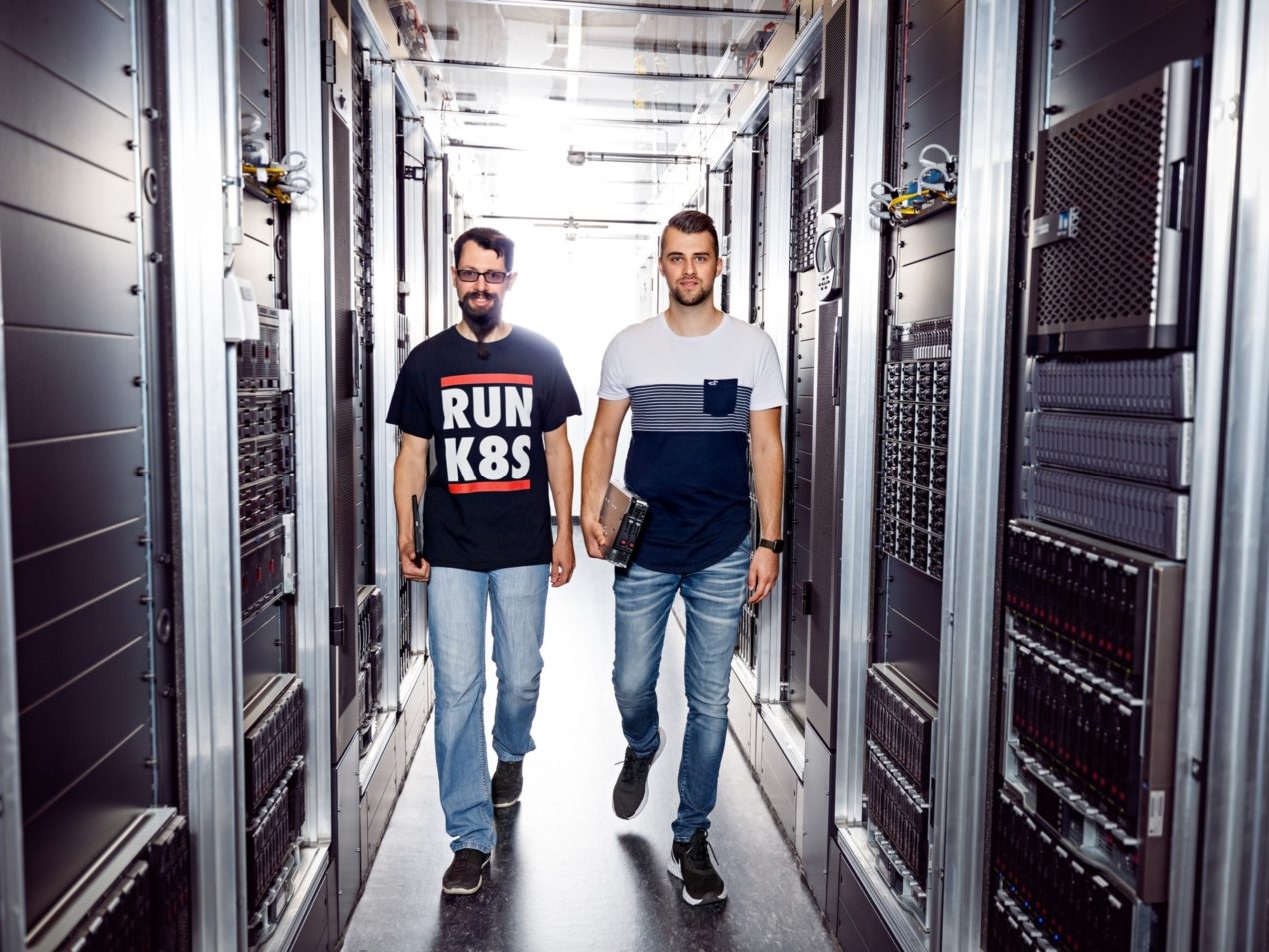 Zwei Mitarbeiter der SIT laufen in einem Serverraum.