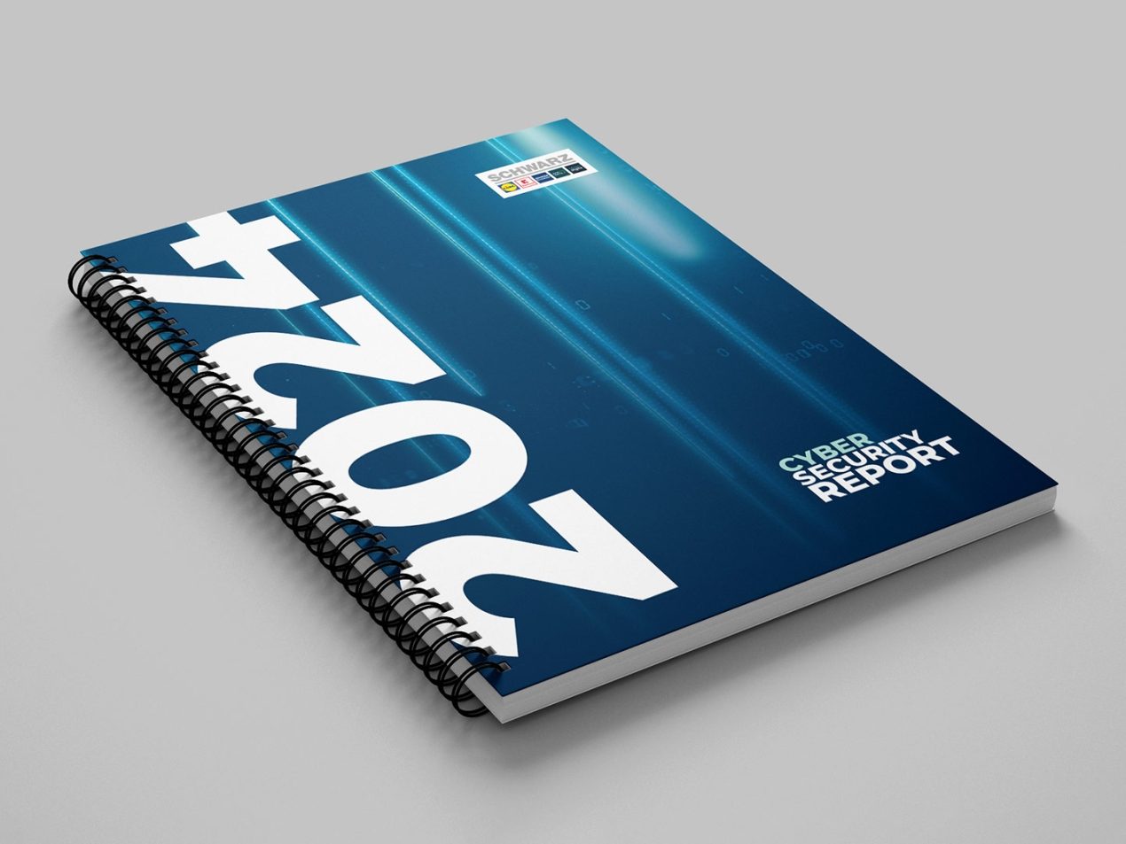 A ring binder in dark blue and turquoise can be seen on a gray background. Cyber Security Report 2024 can be read in white lettering.