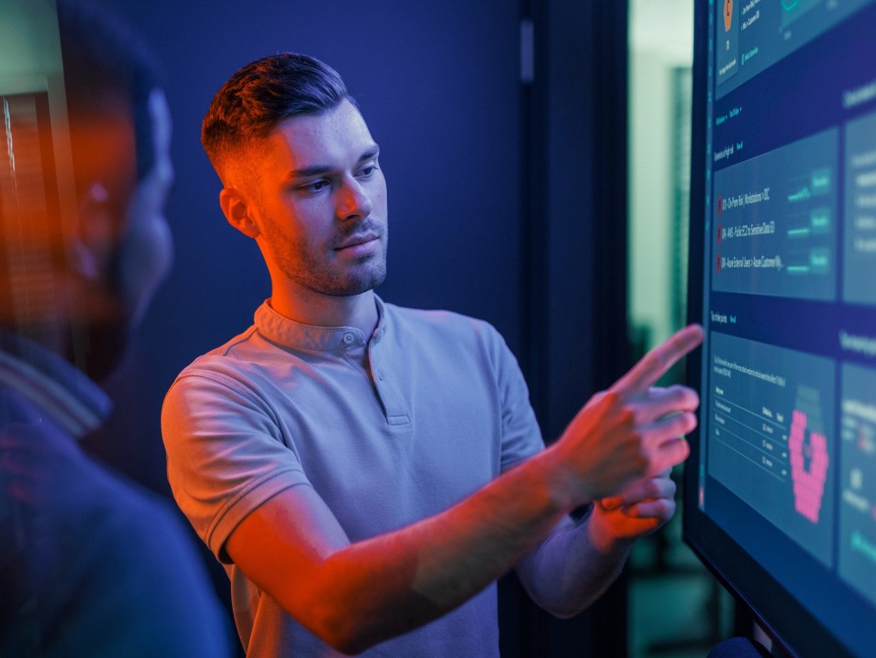 IT specialist showing data on a dashboard screen.