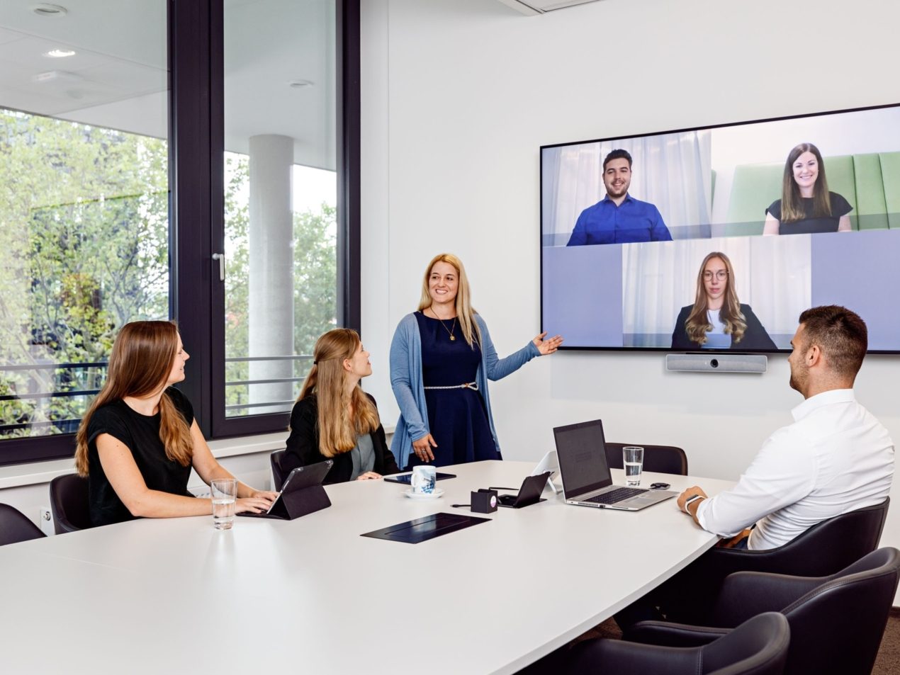 Vier Mitarbeiter der SIT in einem Besprechungsraum. Per Teams sind weitere drei Mitarbeiter zur Besprechung zugeschaltet.