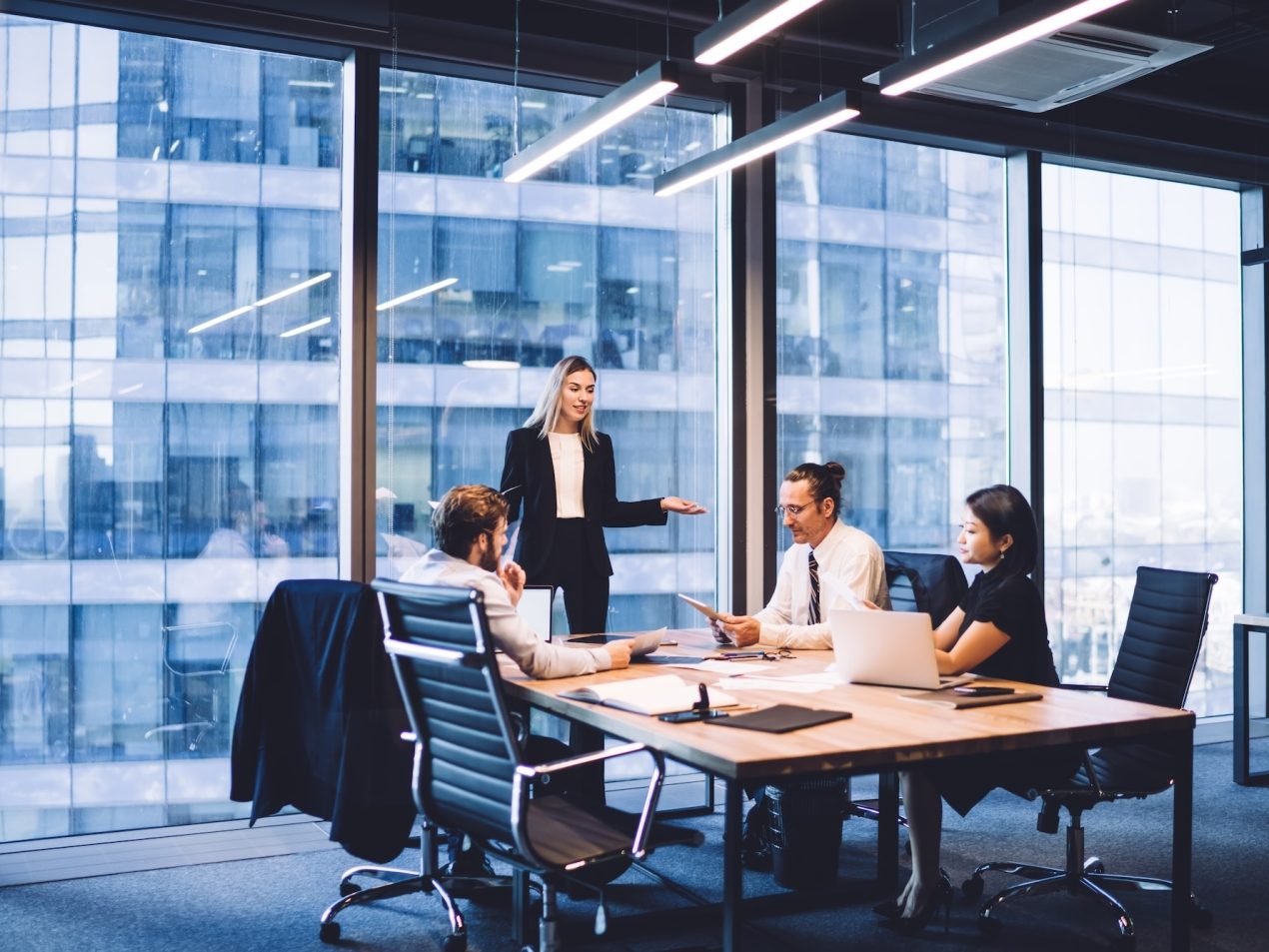 Conference room with people sitting at the table with laptops