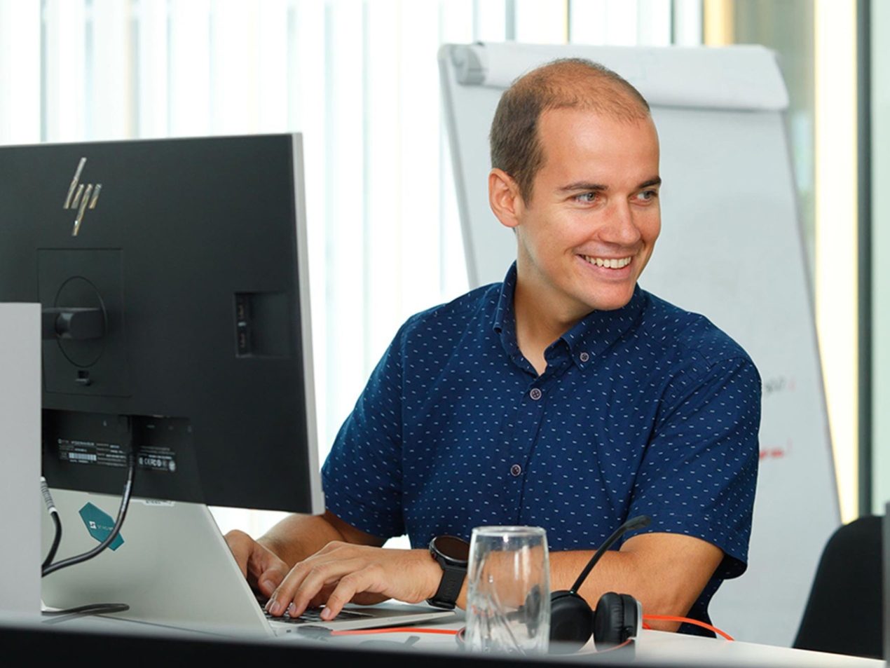 Ein Mitarbeiter sitzt an seinem Arbeitsplatz an einem Computer