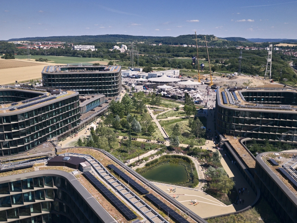 Luftaufnahme des Schwarz Digits Campus in Bad Friedrichshall mit modernen Bürogebäuden, Begrünung, Teich und Solaranlagen.