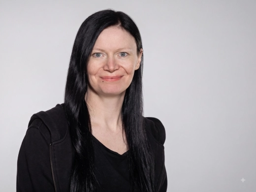 Jasmin Becker, Change Managerin bei PCG, mit langen schwarzen Haaren und blauen Augen auf einem professionellen Porträtfoto vor weißem Hintergrund.