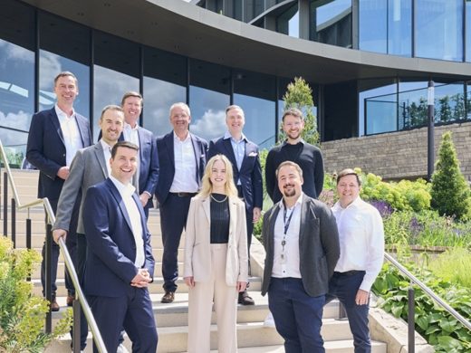 Schwarz Digits and Zscaler team standing on outdoor stairs in front of a modern office building