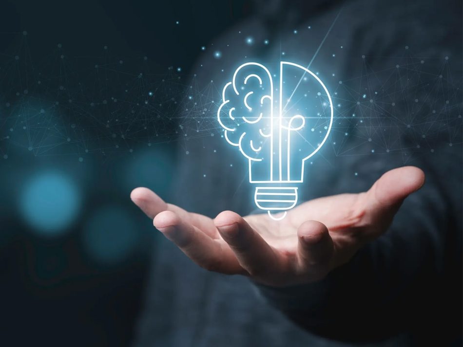 Person hält digitalisierte Glühbirne, die zur einen Hälfte eine illustrierte Hirnhälfte und zur anderen Hälfte eine Glühbirne zeigt