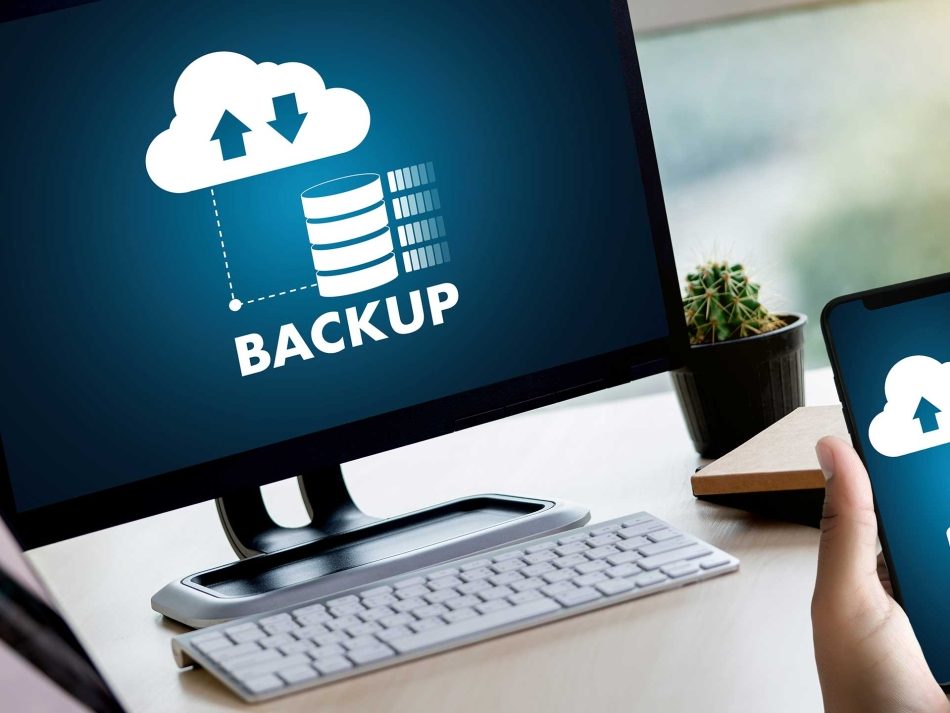 Professionelle Datensicherung mit Cloud Backup: Ein Desktop-Monitor visualisiert die Sicherung von Serverdaten, während ein Smartphone die Sicherung mobiler Daten in die Cloud zeigt, unterstrichen durch das Cloud-Symbol und den Text 'BACKUP'.