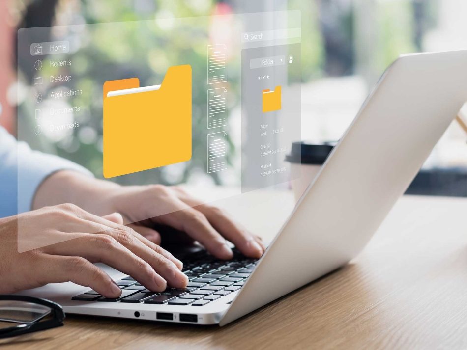 Hands typing on a laptop with a glowing holographic file folder system, representing digital administration, a paperless office, and secure document management.