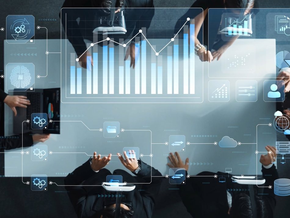 Geschäftsmeeting von oben: Ein Team mit VR-Brillen analysiert schwebende digitale Diagramme, Daten und KI-Symbole an einem Tisch.