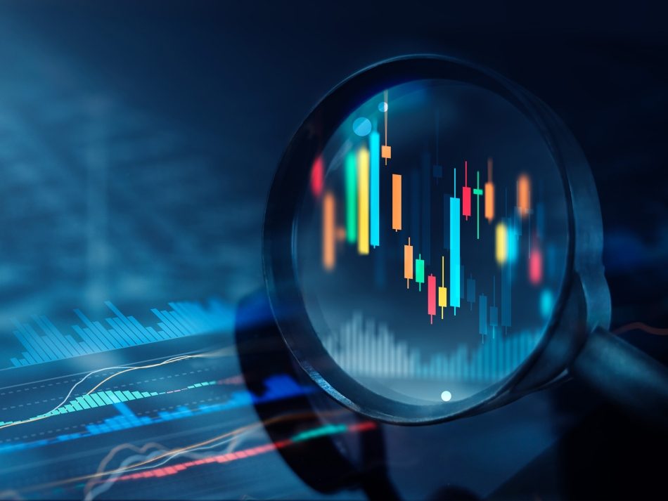 Close-up of a magnifying glass enlarging a candlestick chart on a digital screen. Financial analysis, trading, and stock market data.