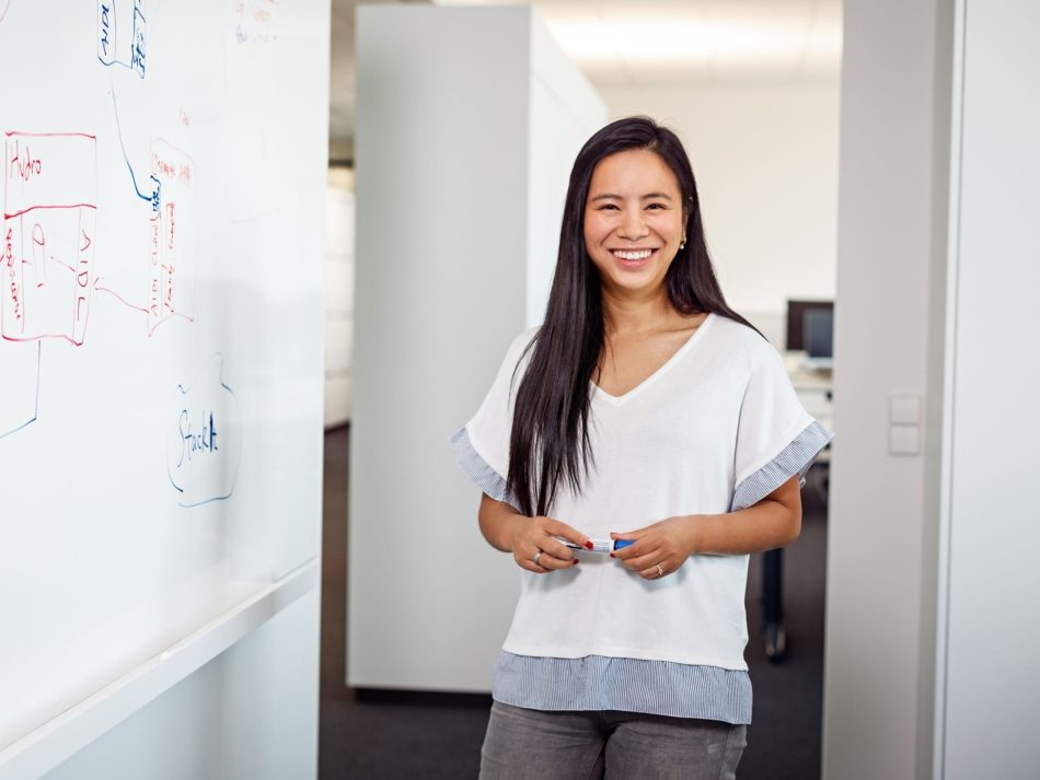 Eine Mitarbeiterin der SIT steht vor eine beschriebenen Whiteboard.
