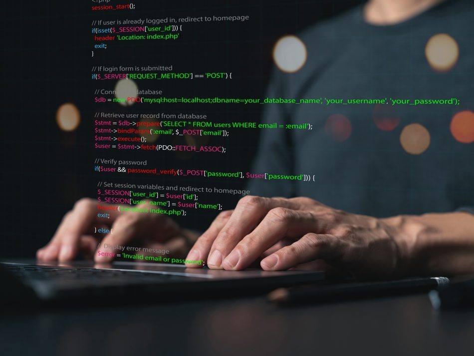 Nahaufnahme von Händen auf einer Laptop-Tastatur mit einem Overlay aus buntem Programmcode für KI-gestützte Softwareentwicklung.