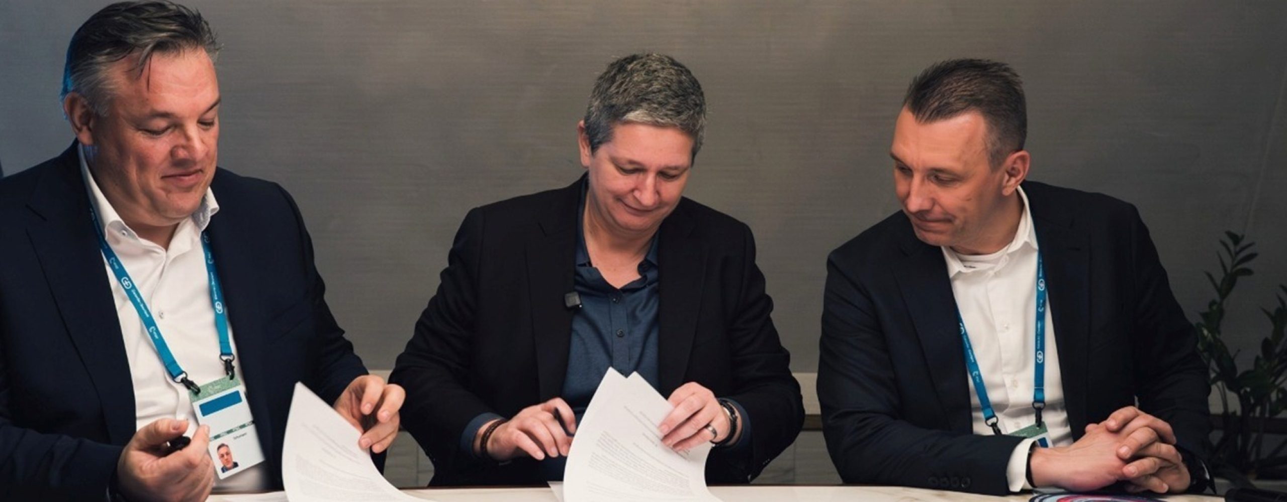 Shaping digital sovereignty together: BSI President Claudia Plattner in the center, flanked by Schwarz Digits Co-CEOs Rolf Schumann and Christian Müller as they review and sign documents.