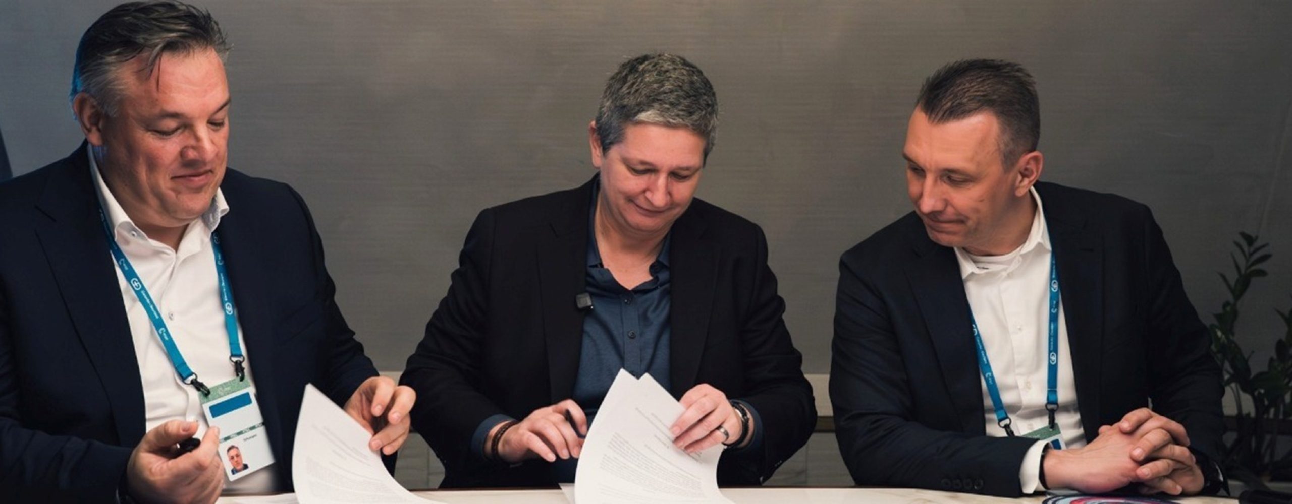 Digital Souveränität gemeinsam gestalten: In der Mitte BSI-Präsidentin Claudia Plattner, links und rechts die Schwarz Digits Co-CEOs Rolf Schumann und Christian Müller beim Sichten und Unterzeichnen von Dokumenten.